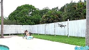 Teen lesbians engage in playful tug-of-war with a drone outdoors.
