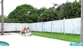 Teen lesbians engage in playful tug-of-war with a drone outdoors.