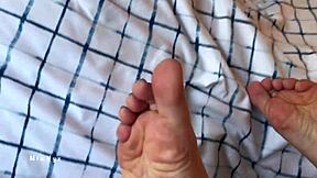 Bare feet in bed with Mianyx teasing toes and blue pedicure