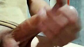 I'm masturbating in the bathroom at my job, feeling horny and reaching orgasm with my cock