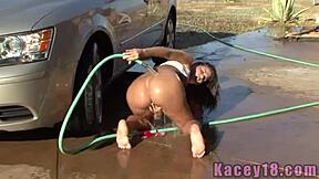 This wet teen babe Kacey is posing outdoors in the car, teasing with ripped clothes