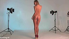 blonde teen 18+ with bright hazel eyes stands nude here