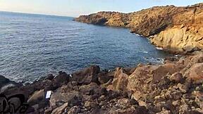 Teen gives blowjob on seaside cliff.