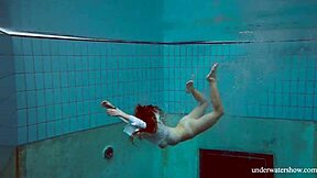 Lola shows her big natural tits while swimming underwater.