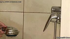 An unidentified person appears in a bathing scene involving old and young individuals in the shower.