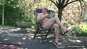 Teen neighbor teases old man into outdoor sex in his backyard garden.